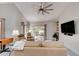 Inviting living room featuring a large TV, ceiling fan, comfortable seating, and sliding glass doors to the patio at 1903 Sprucewood Way, Port Orange, FL 32128