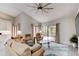 Bright living room featuring high ceilings, neutral tones, ceiling fan, and sliding glass doors to a screened in lanai at 1903 Sprucewood Way, Port Orange, FL 32128