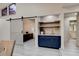 Stylish nook with a barn door, navy cabinets, granite countertops, and views of an office for modern living and working at 1903 Sprucewood Way, Port Orange, FL 32128