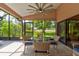 Covered outdoor patio with glass table, comfortable seating, and view of lush landscaping at 1903 Sprucewood Way, Port Orange, FL 32128