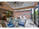 Covered patio features a glass table surrounded by wicker chairs, two sun loungers and neutral tile floors at 1903 Sprucewood Way, Port Orange, FL 32128