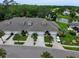 An aerial view displays the lovely townhomes backing to a serene pond with mature trees at 1903 Turnbull Lakes Dr # 1903, New Smyrna Beach, FL 32168