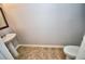 Cozy half bath featuring a pedestal sink, toilet, tiled floor, and a warm color scheme at 1903 Turnbull Lakes Dr # 1903, New Smyrna Beach, FL 32168