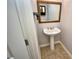 Elegant half bath with pedestal sink, decorative mirror, and tiled flooring at 1903 Turnbull Lakes Dr # 1903, New Smyrna Beach, FL 32168