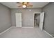 A bedroom with gray carpet features an open door to another room and a ceiling fan at 1903 Turnbull Lakes Dr # 1903, New Smyrna Beach, FL 32168
