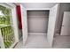 A large bedroom closet has double doors that open to shelving and clothes rod, with a view to a balcony at 1903 Turnbull Lakes Dr # 1903, New Smyrna Beach, FL 32168