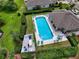 Aerial view of a sparkling community pool surrounded by lush green landscaping and plenty of seating at 1903 Turnbull Lakes Dr # 1903, New Smyrna Beach, FL 32168