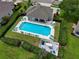 Aerial view of a sparkling community pool surrounded by lush green landscaping and plenty of seating at 1903 Turnbull Lakes Dr # 1903, New Smyrna Beach, FL 32168