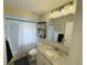 Bright bathroom features a shower-tub combo and vanity with granite countertop at 208 Wellington Dr, Daytona Beach, FL 32119