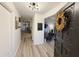 Inviting foyer with wood-look floors, modern light fixture, and a decorative wreath on the front door at 208 Wellington Dr, Daytona Beach, FL 32119
