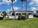 Backyard view showcasing the condo's exterior, with a lush lawn and tropical landscaping at 2100 N Peninsula Ave # 2160, New Smyrna Beach, FL 32169