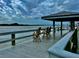 Relaxing dock view with chairs under a shaded structure, overlooking peaceful water at 2100 N Peninsula Ave # 2160, New Smyrna Beach, FL 32169
