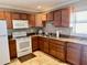 Functional kitchen featuring wooden cabinets, granite countertops, and modern appliances for easy meal preparation at 2100 N Peninsula Ave # 2160, New Smyrna Beach, FL 32169