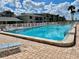Beautiful community pool with clear blue water and inviting lounge chairs under a bright blue sky with fluffy clouds at 2100 N Peninsula Ave # 2160, New Smyrna Beach, FL 32169