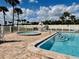 Inviting community pool and spa area with ample seating, palm trees, and a well-maintained patio at 2100 N Peninsula Ave # 2160, New Smyrna Beach, FL 32169