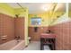 Retro full bathroom with tiled bathtub and shower, toilet, and sink at 2107 Saxon Dr, New Smyrna Beach, FL 32169