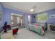 Stylish bedroom with pastel walls, ceiling fan, terrazzo floors, and sliding glass doors to the patio at 2107 Saxon Dr, New Smyrna Beach, FL 32169