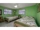 Bright bedroom with two twin beds, terrazzo floors, and windows at 2107 Saxon Dr, New Smyrna Beach, FL 32169