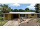 A cozy one-story home features a covered carport and artful drought-tolerant front yard landscaping at 2107 Saxon Dr, New Smyrna Beach, FL 32169