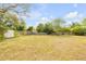 Large grassy fenced backyard with a storage shed and mature trees offering shade and privacy at 2435 Alton Rd, Deltona, FL 32738