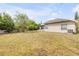 Expansive backyard featuring lush greenery, a screened-in lanai, and ample space for outdoor activities at 2435 Alton Rd, Deltona, FL 32738