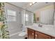 Cozy bathroom with a shower-tub combo, a sink with a cabinet, and a large mirror with light fixtures at 2435 Alton Rd, Deltona, FL 32738