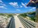Scenic beach access point with wooden walkway amidst natural dunes and vegetation leading to a pristine sandy shoreline at 250 Minorca Beach Way # 206, New Smyrna Beach, FL 32169