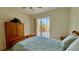 Bedroom with a wooden bedframe and sliding doors to a balcony at 250 Minorca Beach Way # 206, New Smyrna Beach, FL 32169