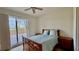 Comfortable bedroom with ceiling fan and sliding glass doors to a spacious patio with building views at 250 Minorca Beach Way # 206, New Smyrna Beach, FL 32169