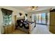 Bedroom with plush bedding, window view, and access to outdoor balcony at 250 Minorca Beach Way # 206, New Smyrna Beach, FL 32169