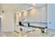 Well-lit kitchen featuring white cabinetry, granite countertops, and modern appliances, maximizing counter space at 250 Minorca Beach Way # 206, New Smyrna Beach, FL 32169