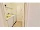 Efficient laundry room with side-by-side washer and dryer, and a wire shelf for storage at 250 Minorca Beach Way # 206, New Smyrna Beach, FL 32169