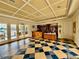 Elegant community library featuring coffered ceilings, tiled floors, built-in bookshelves, and ample natural light at 250 Minorca Beach Way # 206, New Smyrna Beach, FL 32169