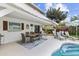Outdoor patio area with dining set and lounge chairs next to a refreshing swimming pool with lush landscaping at 2510 S Atlantic Ave, New Smyrna Beach, FL 32169