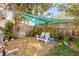 Serene backyard retreat with comfortable seating, shaded by mature trees and a charming fabric canopy at 2510 S Atlantic Ave, New Smyrna Beach, FL 32169