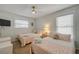 Inviting bedroom with two twin beds, complemented by bright, cheerful decor and a cooling ceiling fan at 2510 S Atlantic Ave, New Smyrna Beach, FL 32169