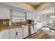 Bright kitchen with stainless steel appliances, granite counters, and a view to the dining area at 2510 S Atlantic Ave, New Smyrna Beach, FL 32169