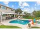 Inviting backyard pool with spa, shaded patio, green grass, and privacy fence at 2510 S Atlantic Ave, New Smyrna Beach, FL 32169