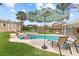 Inviting backyard pool and spa area, featuring an umbrella, lush landscaping, and lounge chairs for relaxation at 2510 S Atlantic Ave, New Smyrna Beach, FL 32169
