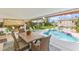 A covered outdoor dining area next to the swimming pool and manicured backyard at 2510 S Atlantic Ave, New Smyrna Beach, FL 32169
