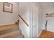 Neutral stairway with carpeted steps and a wooden handrail, adjacent to hallway and coat closet at 2510 S Atlantic Ave, New Smyrna Beach, FL 32169