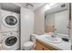 Bathroom includes a washer/dryer combination, floral wallpaper, and a vanity with a sink at 257 Club House Blvd, New Smyrna Beach, FL 32168