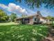 Expansive backyard with a unique stone chimney, screened in porch, and well maintained greenery at 257 Sweet Bay Dr, New Smyrna Beach, FL 32168