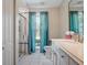 Clean bathroom featuring a glass-enclosed shower, tiled floors, and ample natural light at 257 Sweet Bay Dr, New Smyrna Beach, FL 32168