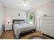 Comfortable bedroom with wood floors, a ceiling fan, and a large window at 257 Sweet Bay Dr, New Smyrna Beach, FL 32168