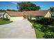Inviting single-story home featuring a circular driveway, two car garage and manicured landscaping at 257 Sweet Bay Dr, New Smyrna Beach, FL 32168