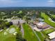 Panoramic aerial shot showcasing the golf course, clubhouse with pool, tennis courts, landscaping, and parking at 257 Sweet Bay Dr, New Smyrna Beach, FL 32168