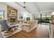 Inviting living room with a stone fireplace, wood floors, and sliding doors to the lanai at 257 Sweet Bay Dr, New Smyrna Beach, FL 32168