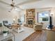 Cozy living room featuring a stone fireplace, beamed ceiling, and comfortable seating with great natural light at 257 Sweet Bay Dr, New Smyrna Beach, FL 32168