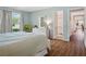 Bright main bedroom featuring wood floors, a view of the pool, and a connecting bathroom at 257 Sweet Bay Dr, New Smyrna Beach, FL 32168
